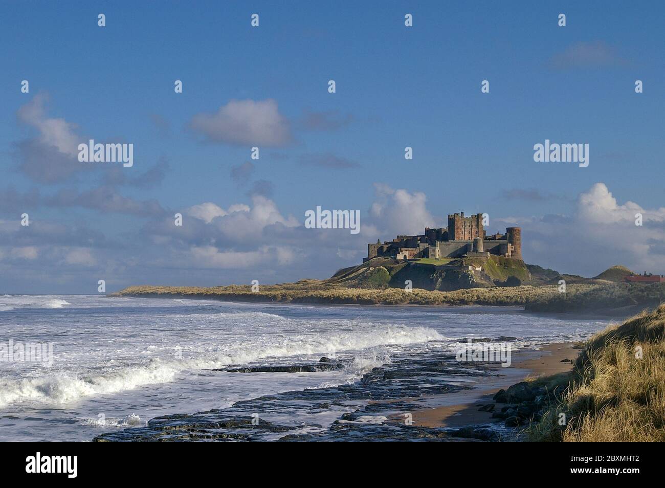 Lo storico Castello di Bambburgh sorge su uno sperone roccioso sulla costa nord-orientale del Northumberland, Inghilterra, Regno Unito Foto Stock