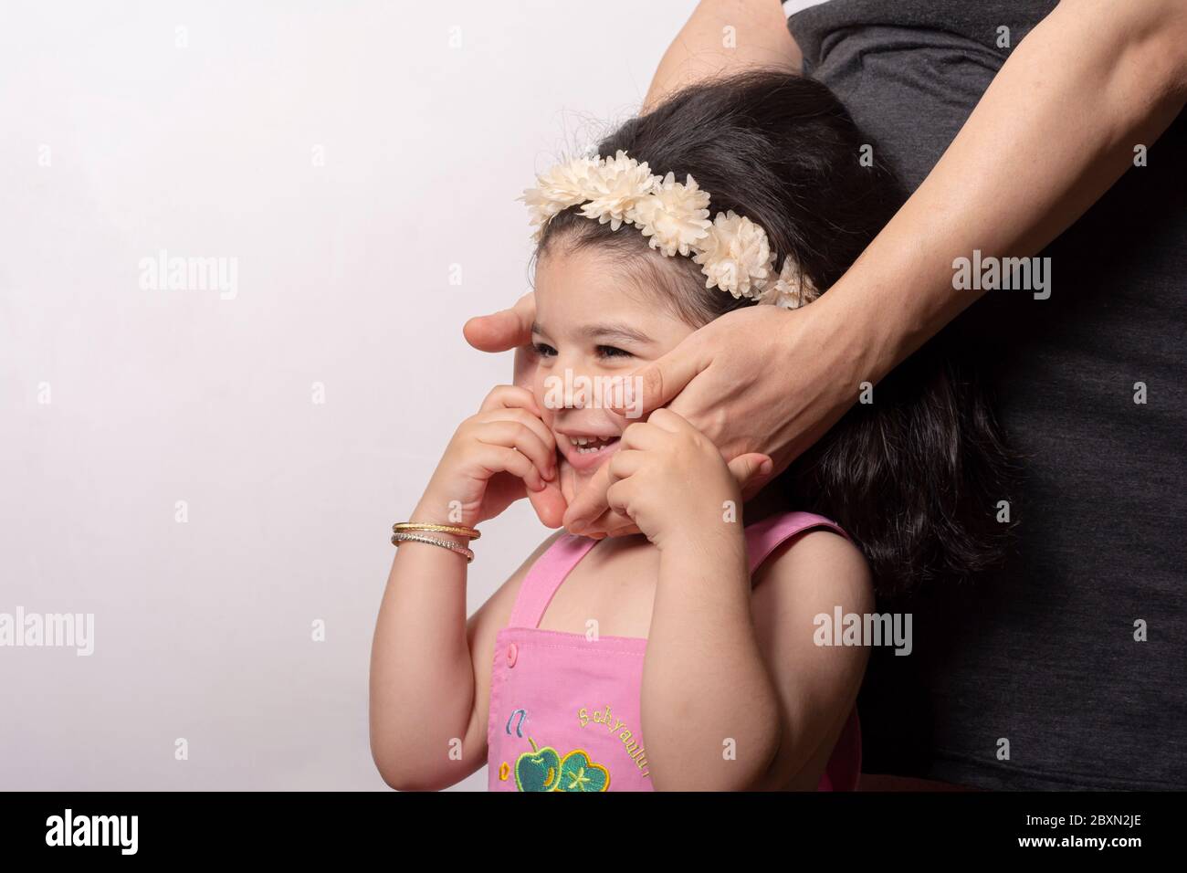 Felice bella sorella di due anni ritratto con la sua madre incinta pancia, genitori e bambini relazione concetto Foto Stock