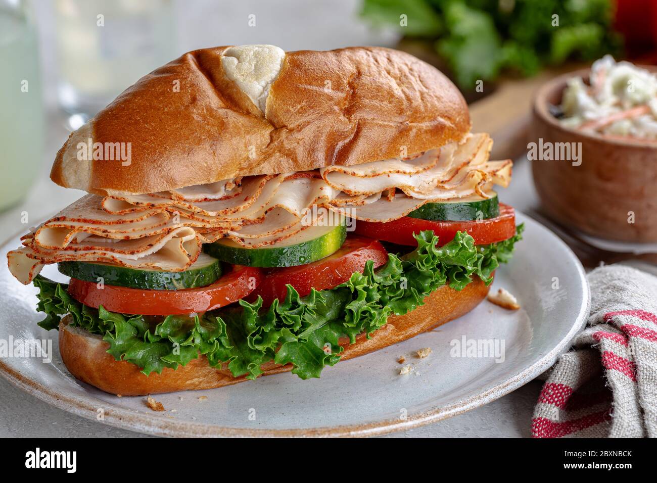 Sandwich di sottomarino tacchino con cetriolo, pomodoro e lattuga su un piatto Foto Stock