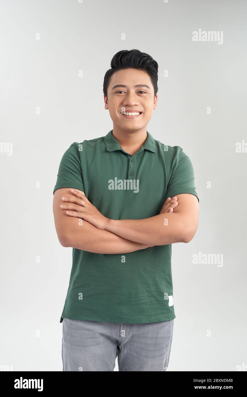 Uomo giovane e dall'aspetto bello che indossa una t-shirt verde. Sfondo bianco. Foto Stock