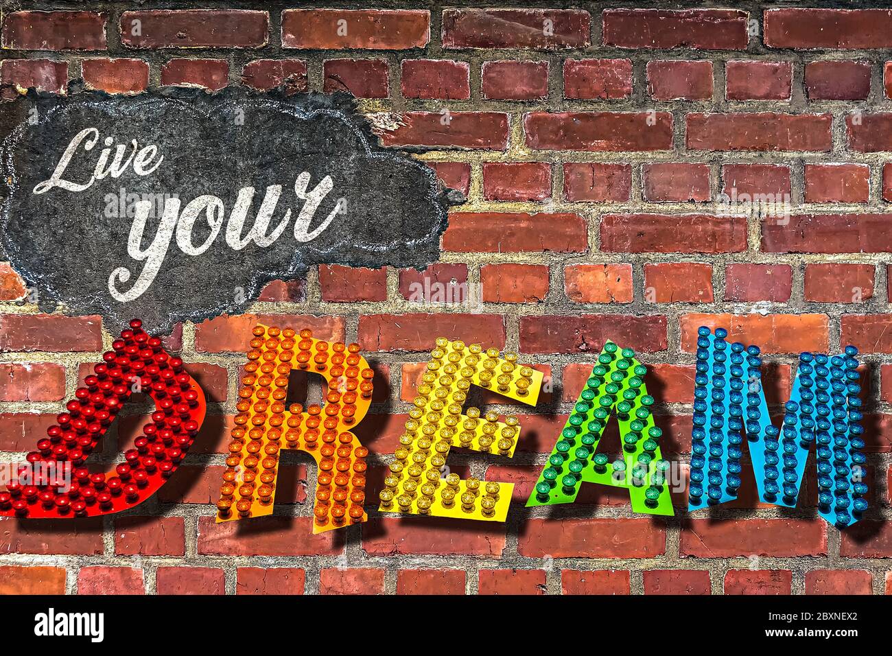 Le parole Live Your Dream scritto su una parete di mattoni rossi Foto Stock