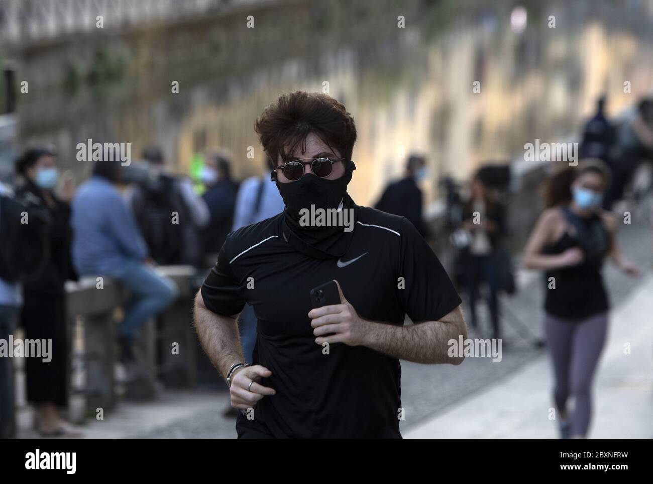 Persone che si fa jogging indossando la maschera durante l'emergenza Covid-19, a Milano. Foto Stock
