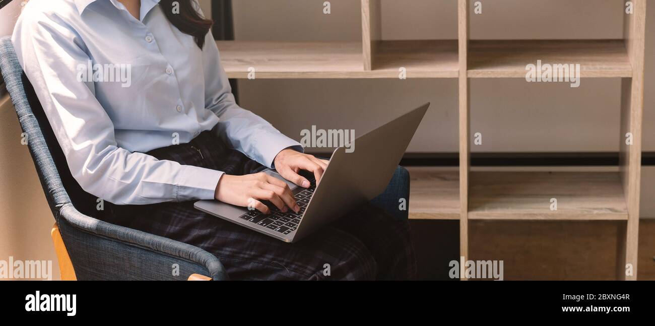 Ritaglia la foto di una donna che usa il suo laptop a casa Foto Stock