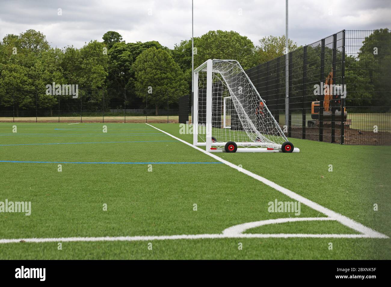 Un campo sportivo di nuova installazione per tutte le stagioni che utilizza erba artificiale. Mostra il layout per il calcio con gol e angolo di campo. Londra, Regno Unito. Foto Stock