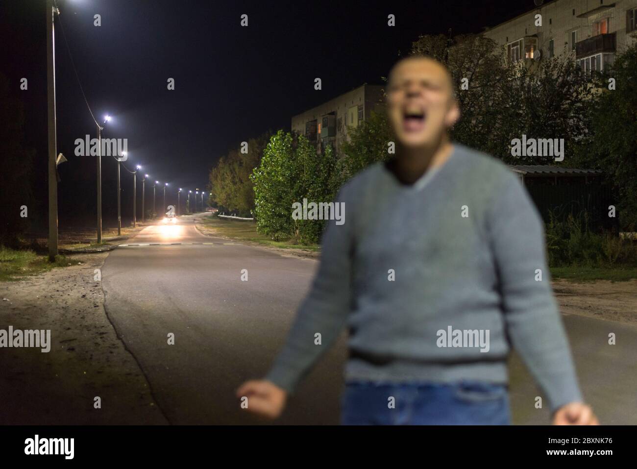 Il fantasma di un ragazzo urlante sulla strada in strada, la foto è fuori fuoco Foto Stock