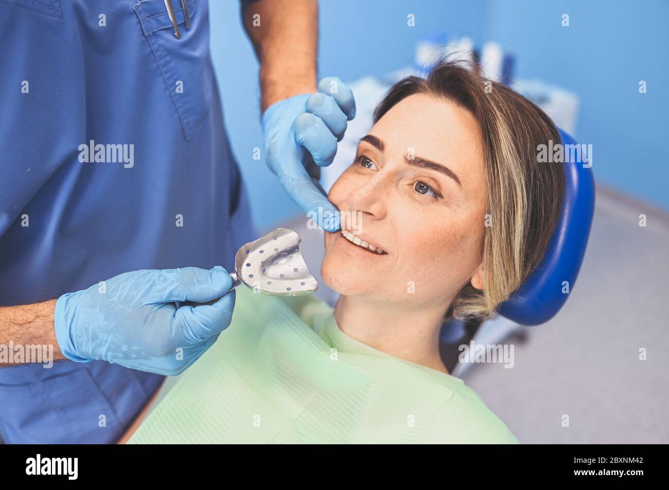 Dentista che esamina i denti di un paziente usando il cucchiaio per impronta  dell'apparecchiatura dentale in studio di odontoiatria. Stomatologia e  concetto di assistenza sanitaria. Medico in dispos Foto stock - Alamy