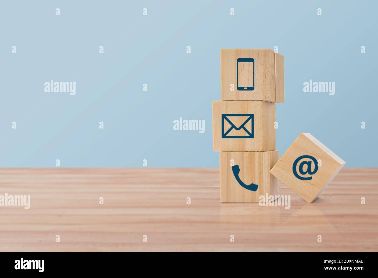 cubo di legno con icona (telefono, e-mail, indirizzo). Concetto di contatto o tema di assistenza clienti. Foto Stock