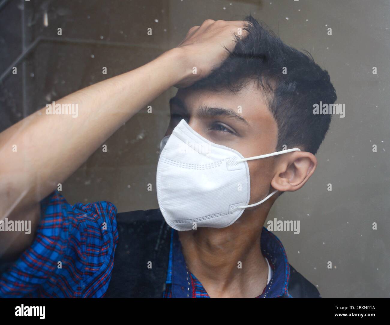Ritratto di un uomo teen che indossa maschera facciale. Vita stressante di studente teen. Foto Stock