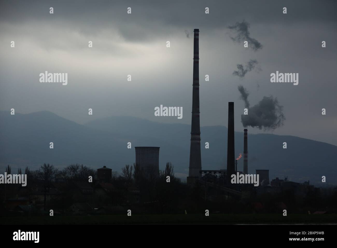 Vista da lontano della città e un camino della fabbrica con un sacco di fumo e smog. Europa, paesaggio Slovacchia, Novaky. Fabbrica chimica. Riassunto. Foto Stock
