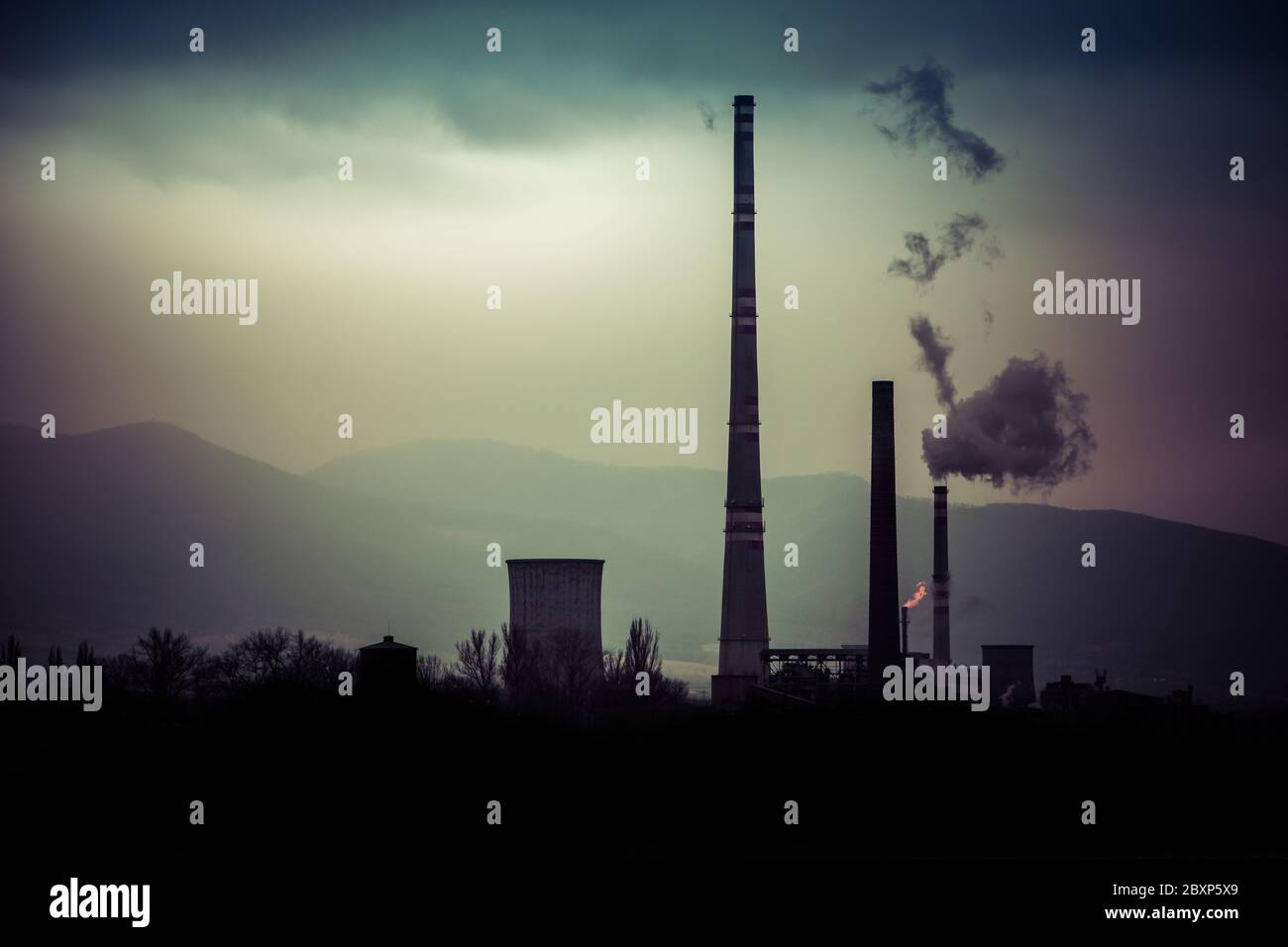 Vista da lontano della città e un camino della fabbrica con un sacco di fumo e smog. Europa, paesaggio Slovacchia, Novaky. Fabbrica chimica. Riassunto. Foto Stock