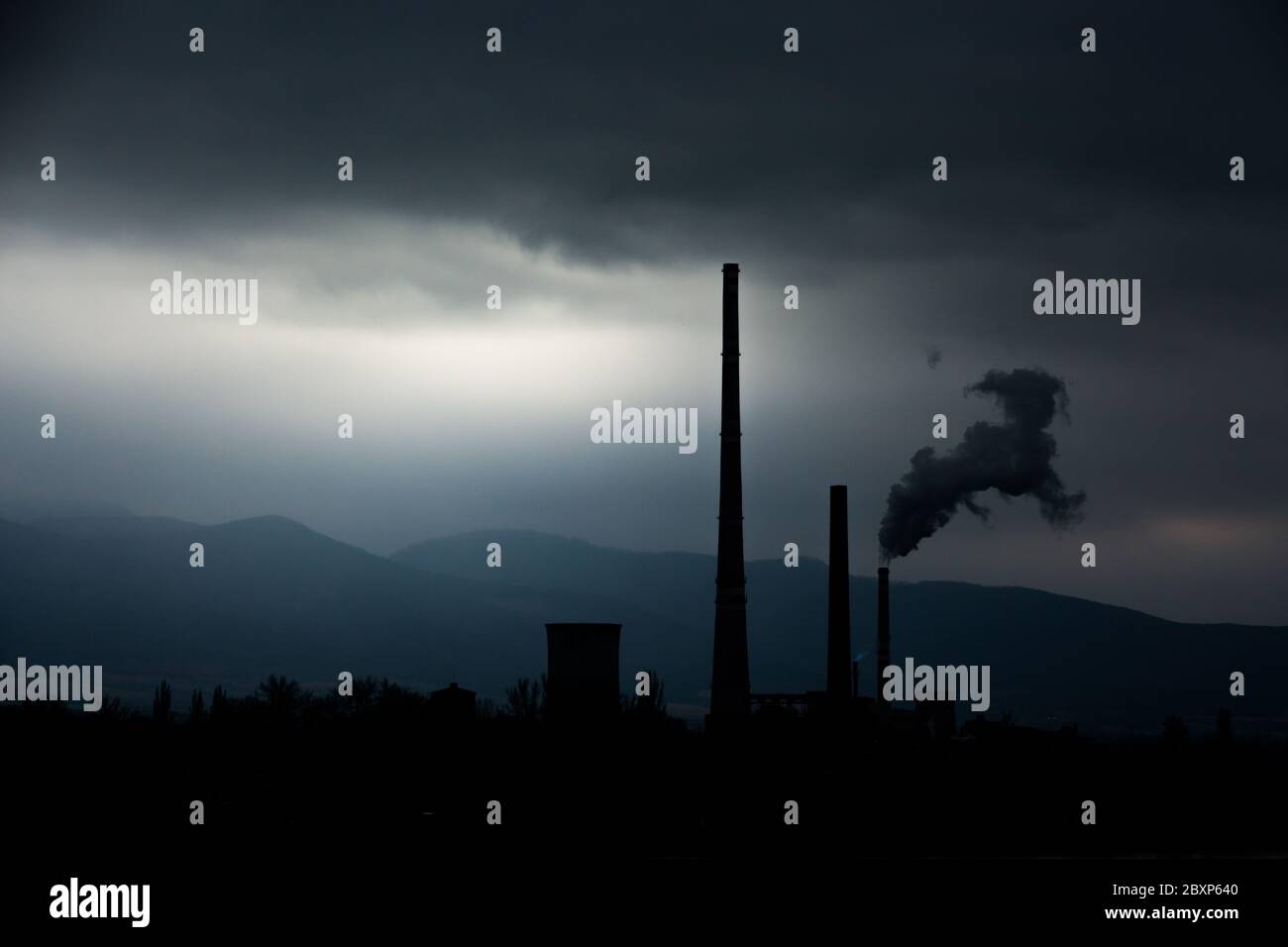 Vista da lontano della città e un camino della fabbrica con un sacco di fumo e smog. Europa, paesaggio Slovacchia, Novaky. Fabbrica chimica. Riassunto. Foto Stock