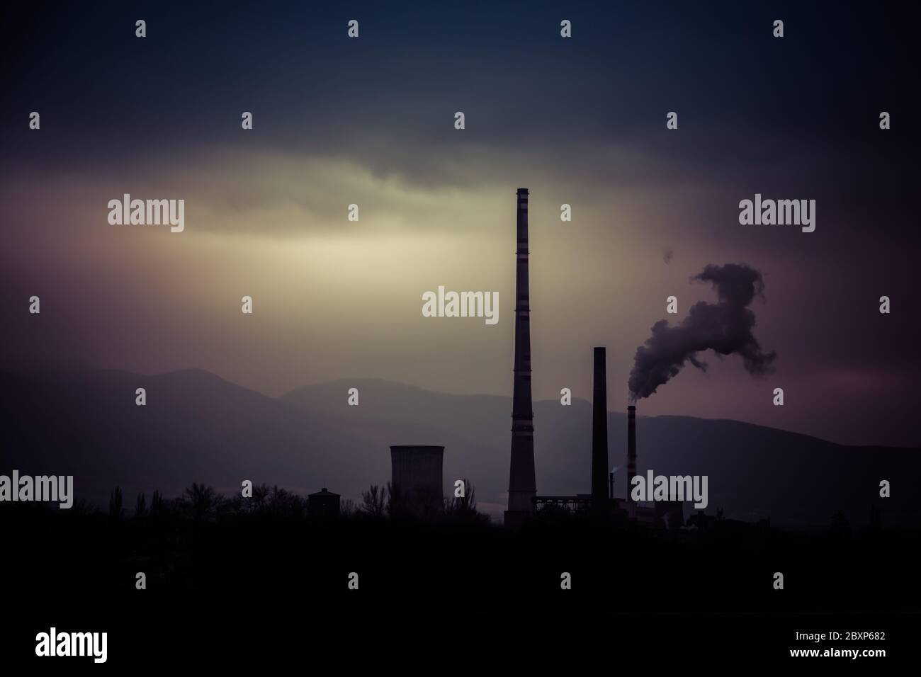 Vista da lontano della città e un camino della fabbrica con un sacco di fumo e smog. Europa, paesaggio Slovacchia, Novaky. Fabbrica chimica. Riassunto. Foto Stock