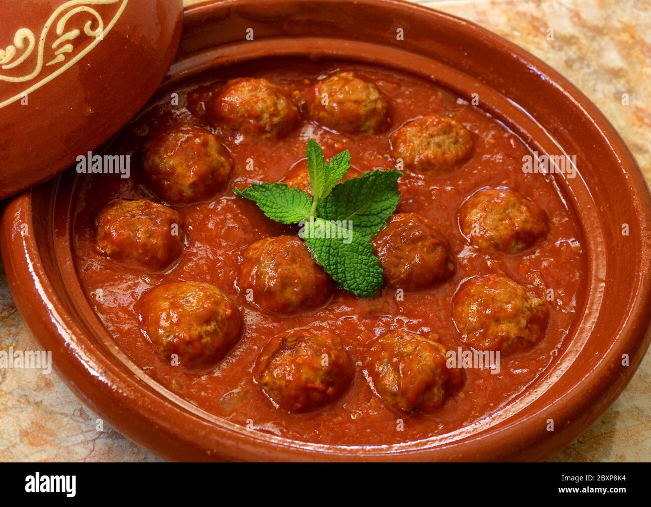 Il Marocco. Kafta tajine - tipici Marocchini e Libanesi piatto di polpette di carne in salsa di pomodoro con la paprika, il cumino, cipolle - cotto in un tagine di argilla. Foto Stock