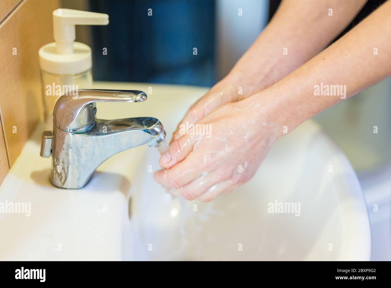 Lavando le mani con sapone sotto il rubinetto con acqua . Concetto di igiene. Foto Stock