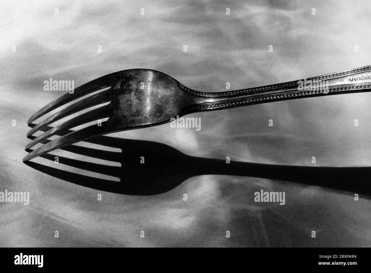 Fotografia in bianco e nero: Una fotografia modernista del XX secolo ha ispirato l'immagine di una forchetta da pranzo e di un'ombra. Foto Stock