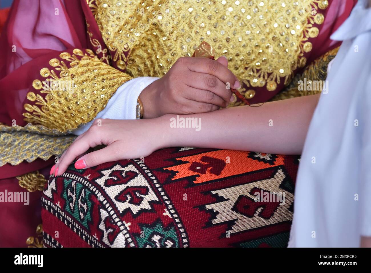 Una donna hennè o un'applier mehndi del Qatar al lavoro. Processo di applicazione dell'hennè tradizionale Mehndi sulla mano femminile Foto Stock