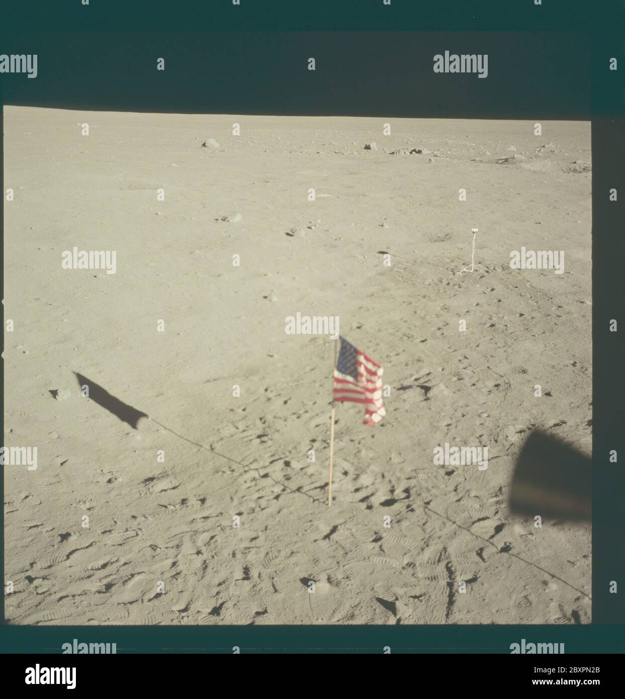 AS11-37-5553 - Apollo 11 - immagine missione Apollo 11 - orizzonte lunare dalla base di tranquillità; ambito e contenuto: Il database originale descrive questo come: Descrizione: Orizzonte lunare dalla base di tranquillità, il sito di atterraggio del modulo lunare (LM). Thruster LM visibili in primo piano. Bandiera degli Stati Uniti visibile sulla superficie lunare. Immagine tratta dall'interno della LM durante la missione Apollo 11. Il film originale è stato etichettato R. Film Type: EKTACHROME EF SO 168 Color su base in poliestere Estar da 2.5 mil, preso con una lente da 80 mm. Angolo solare basso. Inclinazione approssimativa: Media obliqua. Oggetto: Volo Apollo 11, Foto Stock