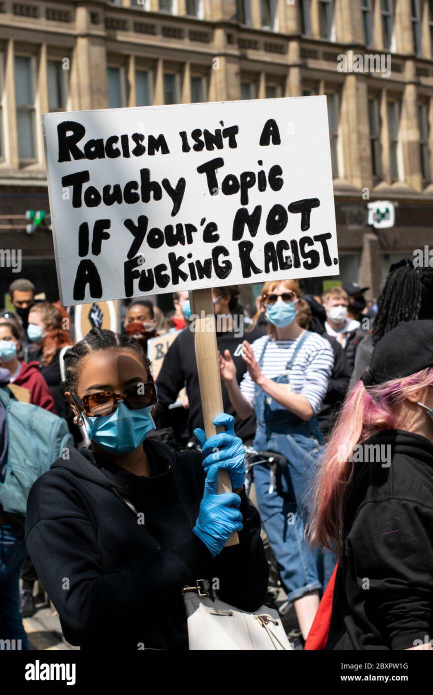 Black Lives Matter protesta, Manchester UK. Protestore con segno dipinto a mano e messaggio di razzismo Foto Stock