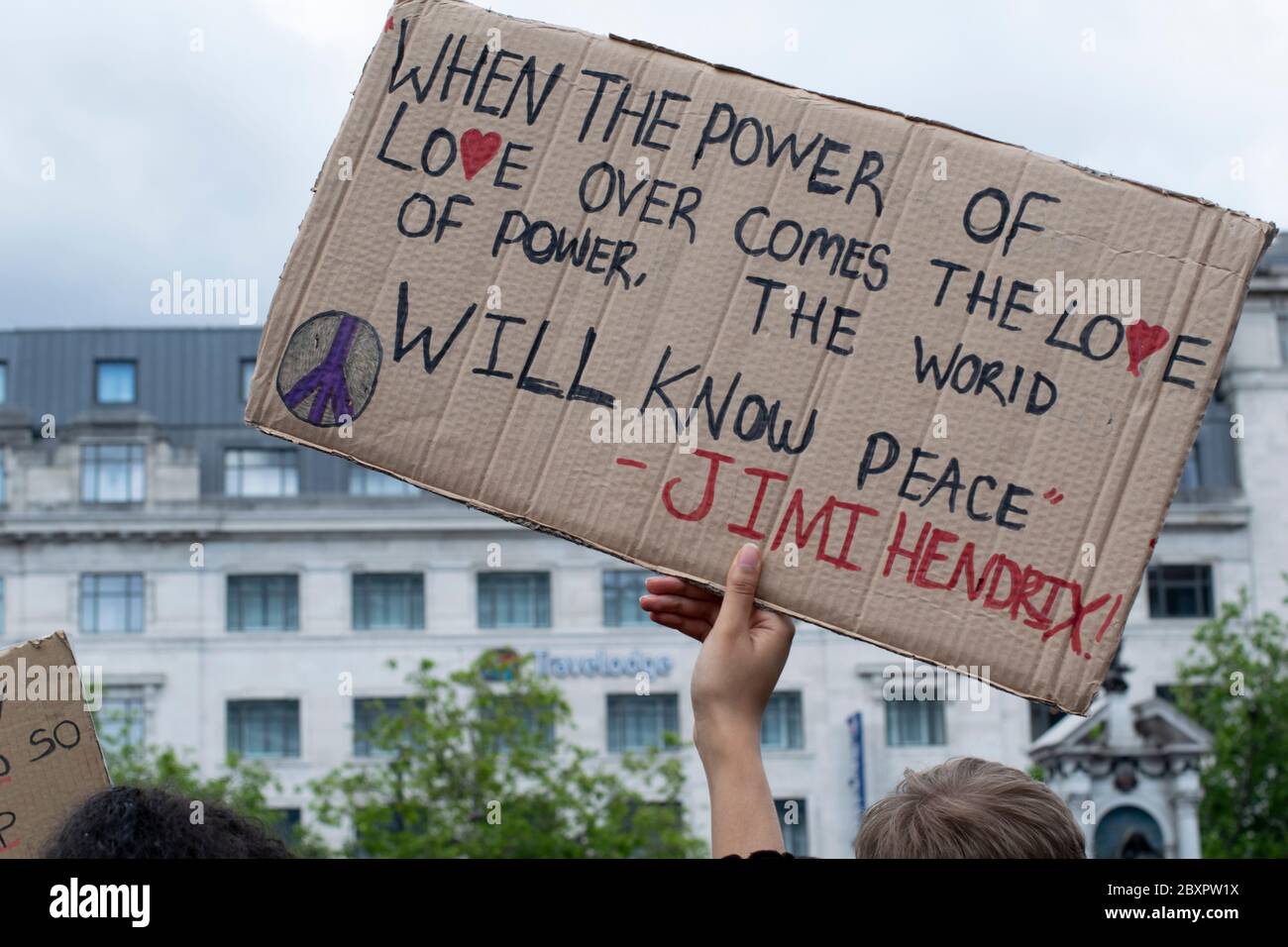 Black Lives Matter protesta, Manchester UK. Placard tenuto in su da mano singola con citazione da Jimi Hendrix su amore Foto Stock