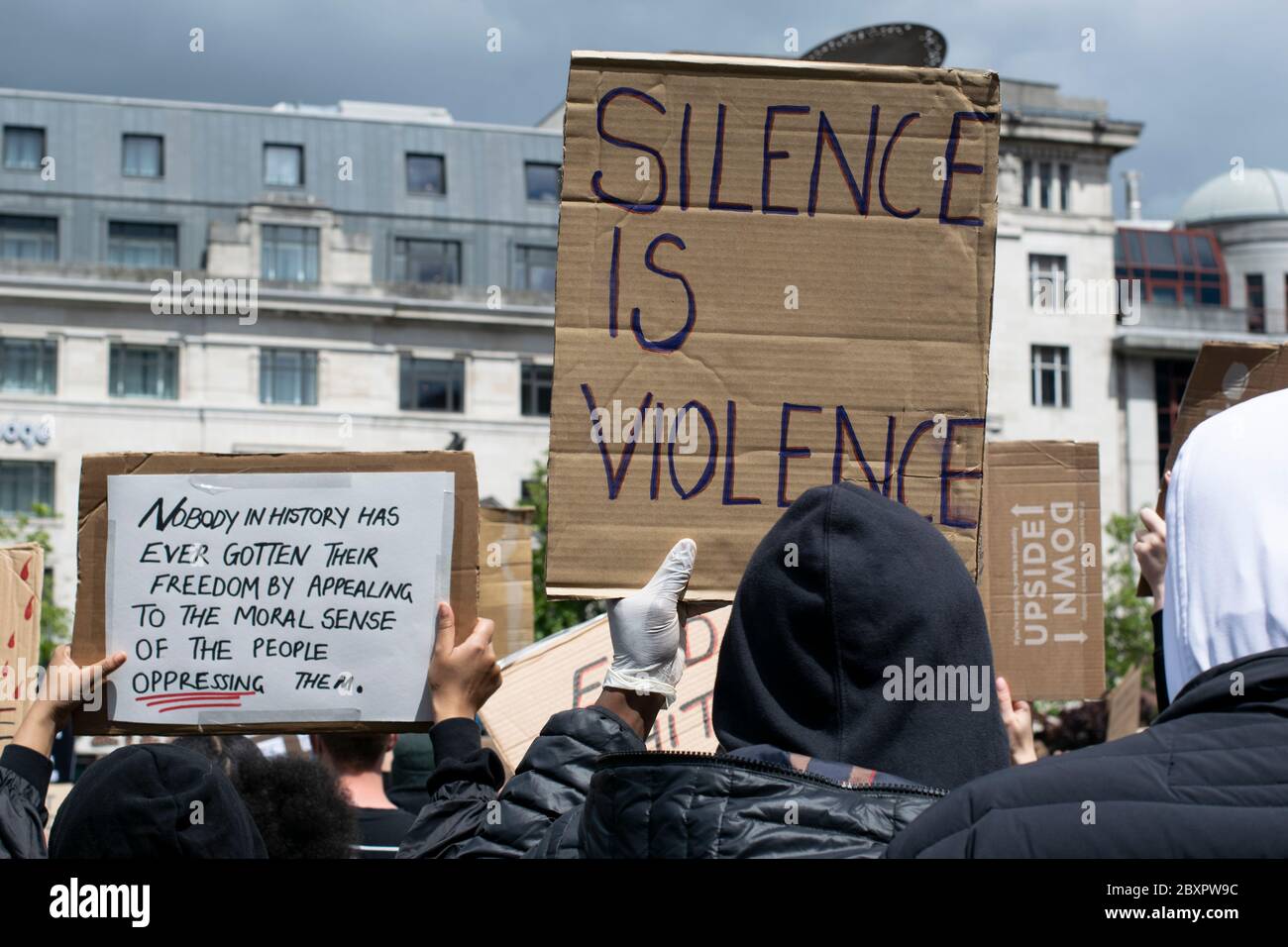 Black Lives Matter protesta, Manchester UK. Il protesto con il cartello dice che il silenzio è violenza Foto Stock