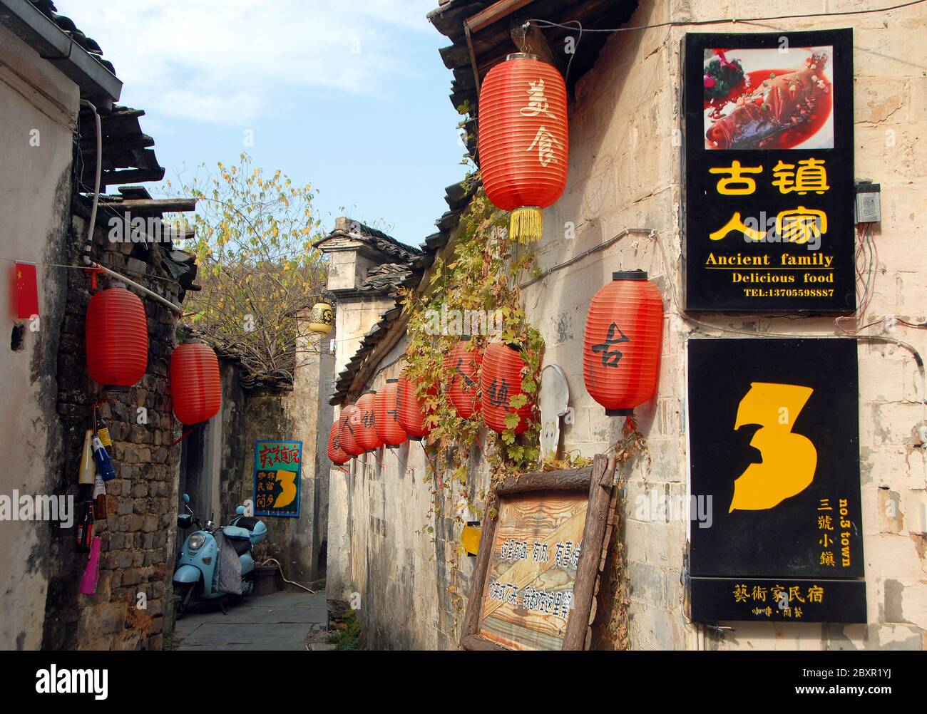 Una lanterna cinese rossa è appesa fuori da un piccolo negozio di vicoli  nell'antica città di Hongcun in Cina Foto stock - Alamy