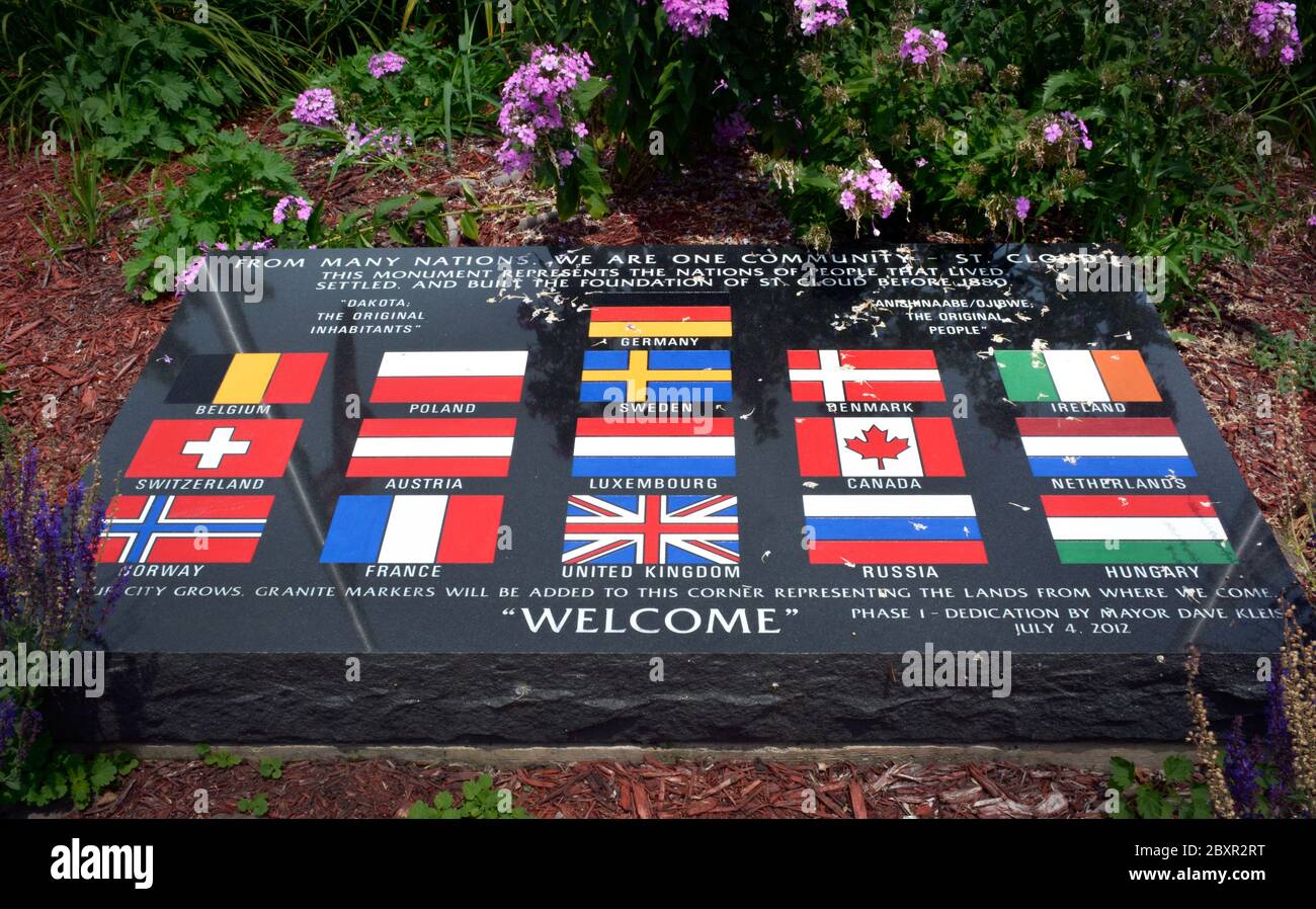 Un monumento colorato con bandiere nazionali e la celebrazione dei molti immigrati che stabilirono St. Cloud, Minnesota prima del 1880, marcatore in granito nero Foto Stock