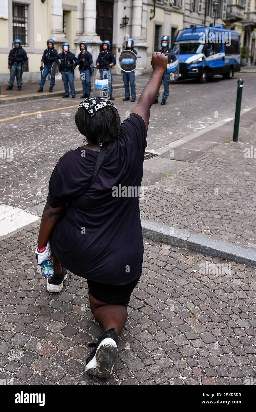 Torino, Italia - 06 giugno 2020: Un protettrice si inginocchia davanti alla polizia durante una manifestazione che chiede giustizia per George Floyd, morto il 25 maggio dopo essere stato trattenuto dalla polizia a Minneapolis, USA. La gente ha protestato pacificamente a Torino per mostrare solidarietà con il movimento anti-razzismo Black Lives Matter negli Stati Uniti e altrove. Credit: Nicolò campo/Alamy Live News Foto Stock