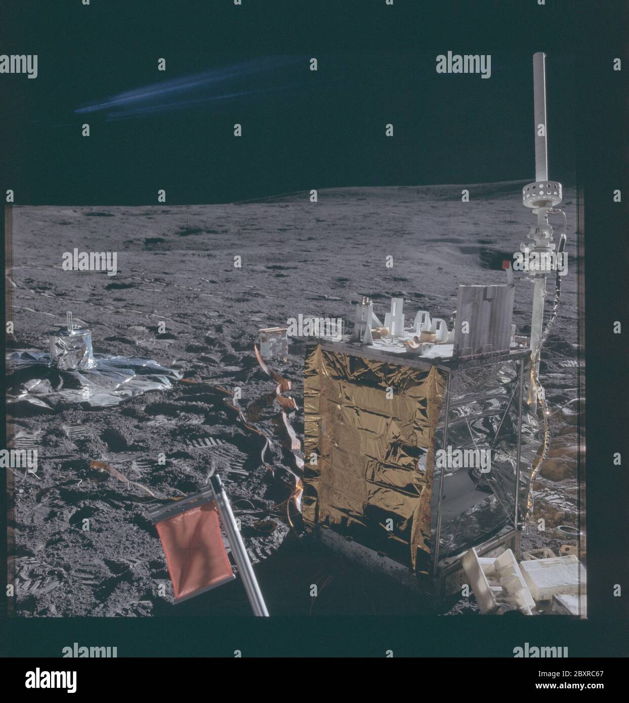 AS14-67-9384 - Apollo 14 - immagine missione Apollo 14 - Vista del pacchetto ALSEP e PSE; ambito e contenuto: Il database originale descrive questo come: Descrizione: Vista del pacchetto Apollo Lunar Surface Experiments Package (ALSEP) per la stazione centrale e il pacchetto PSE (Passive Seismic Experiment). L'antenna ad alta direzione visibile in alto a destra deve essere orientata con precisione verso la terra durante l'attivazione. La cresta che si estende a nord dal cratere del cono forma l'orizzonte lontano dietro l'antenna. Il PSE, coperto da un foglio di alluminio colorato per la protezione termica, si trova al centro sinistro della foto Foto Stock