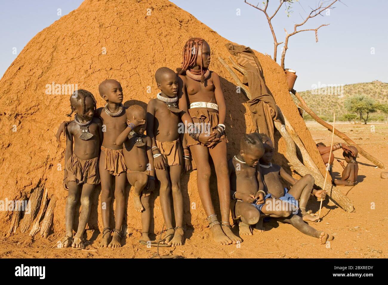 Bambini himba in una tradizionale capanna himba, Africa Foto Stock