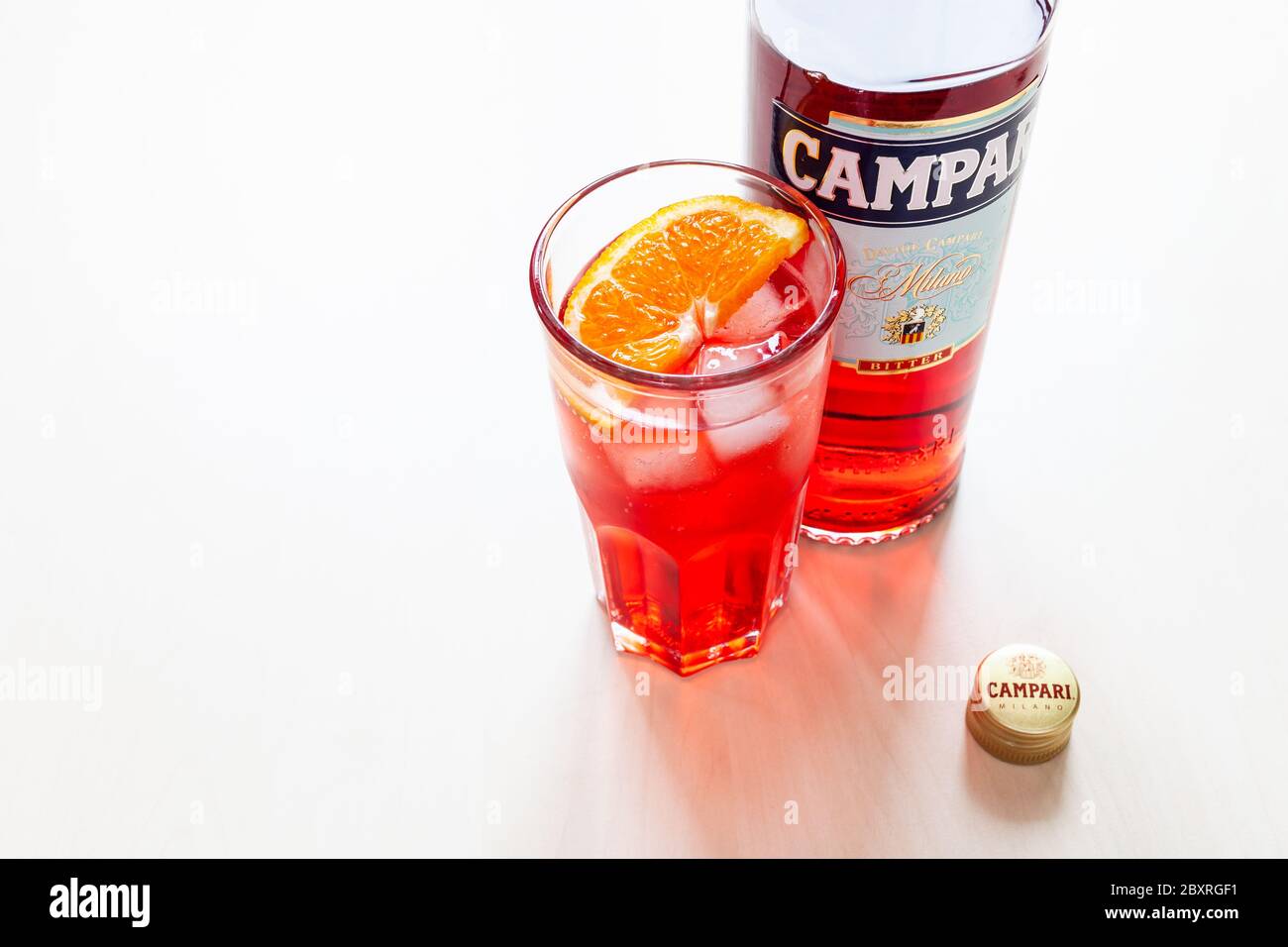 MOSCA, RUSSIA - 4 GIUGNO 2020: Berretto, bicchiere con cocktail e bottiglia di Campari amaro a tavola. Campari è un liquore alcolico italiano appartenente a Davide C. Foto Stock