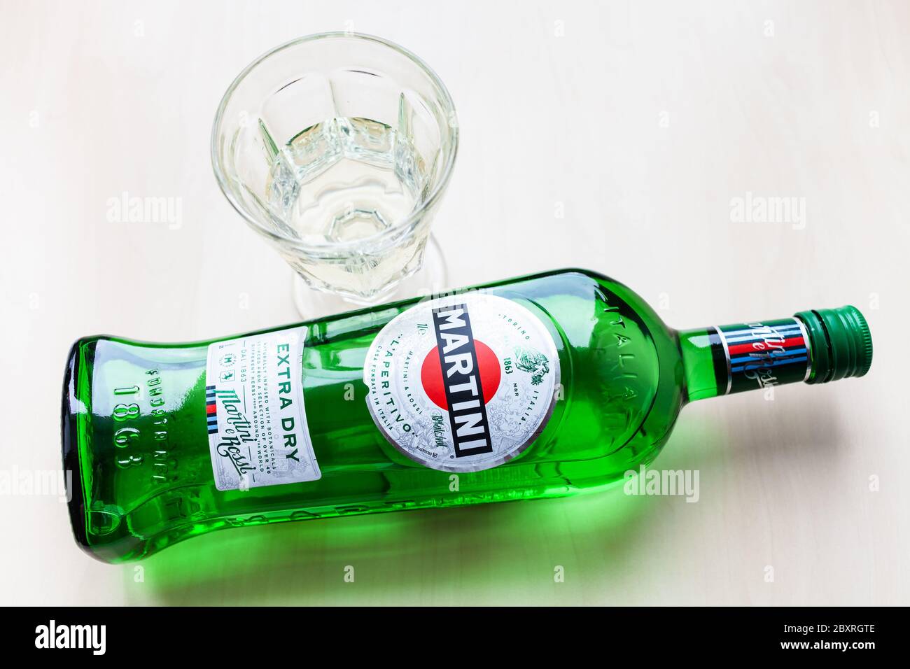 MOSCA, RUSSIA - 23 MAGGIO 2020: Vista dall'alto della bottiglia di Martini Extra Dry e del vetro sul tavolo marrone chiaro. Martini è il classico vermouth italiano Foto Stock