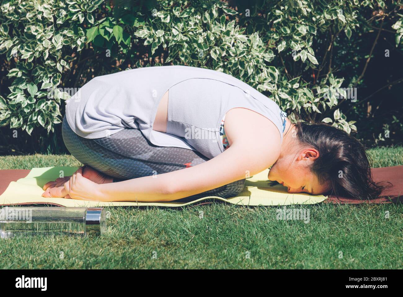 Donna sta facendo yoga in giardino Foto Stock