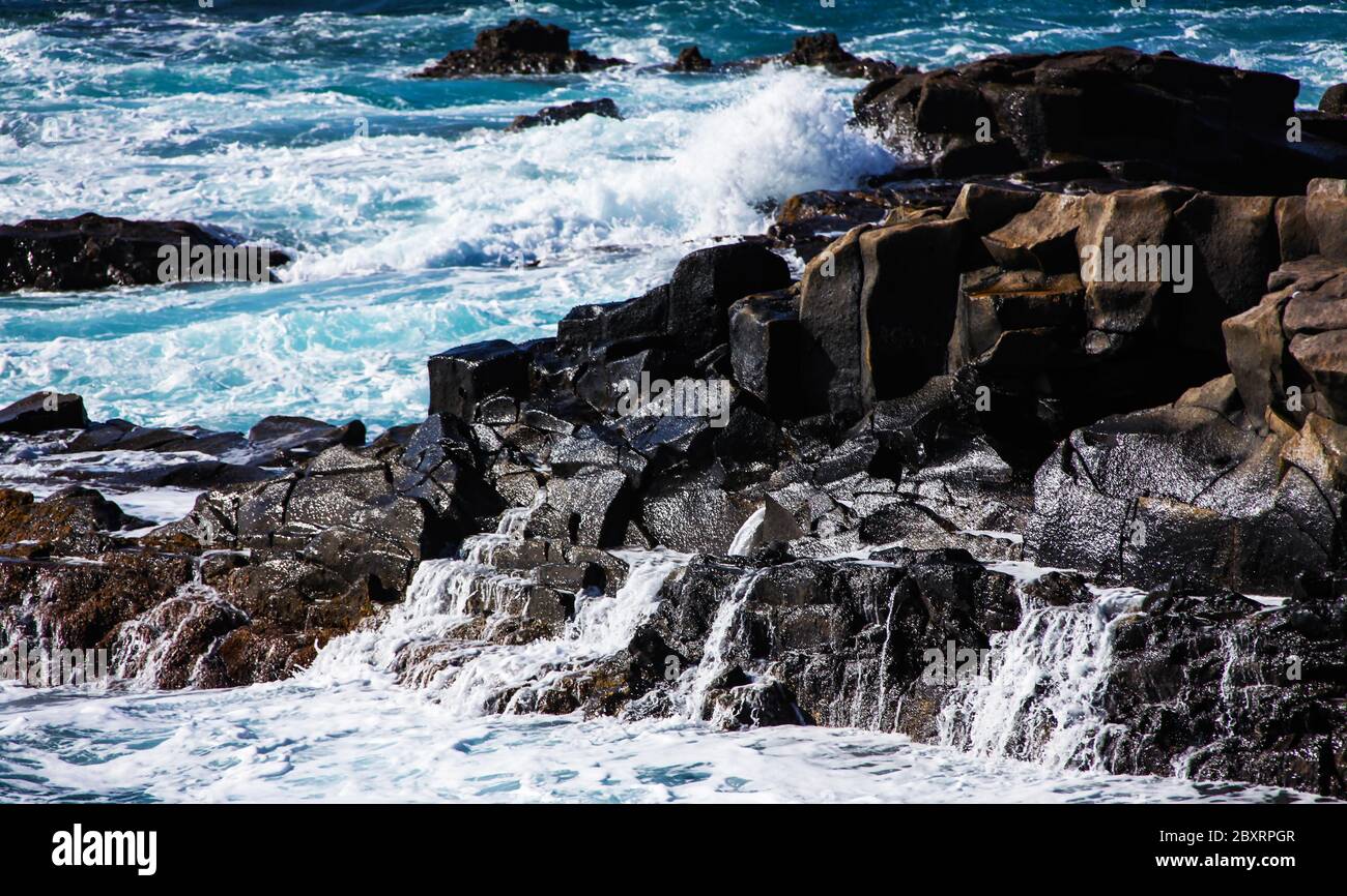 Onde oceaniche che cadono sulla costa, spruzzi d'acqua e goccioline, Tenerife. Foto Stock