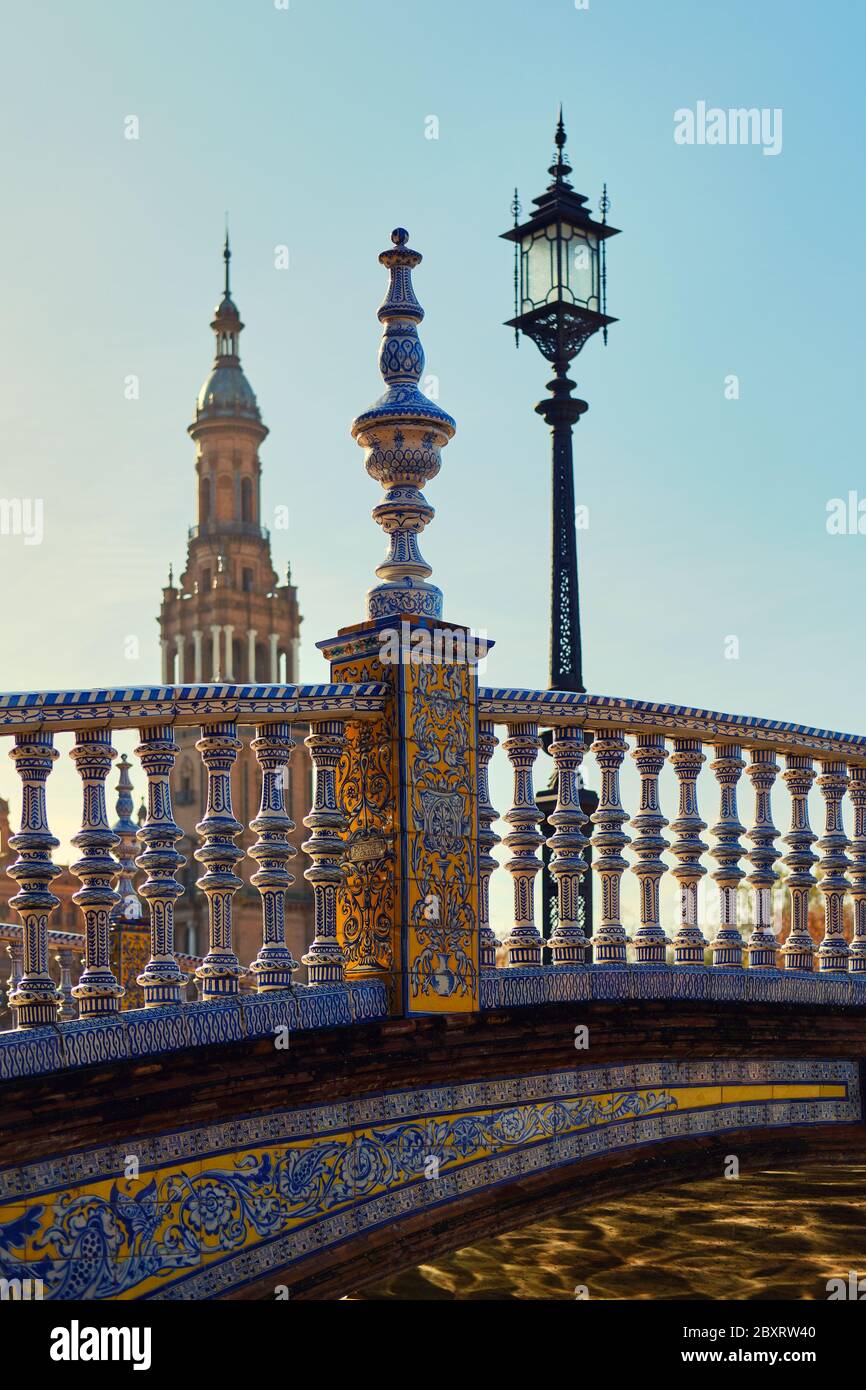 Frammento di ponte decorato con piastrelle di ceramica blu bianco attraverso il fiume Guadalquivir e vista della torre, dettagli architettonici di Plaza de Espana Foto Stock