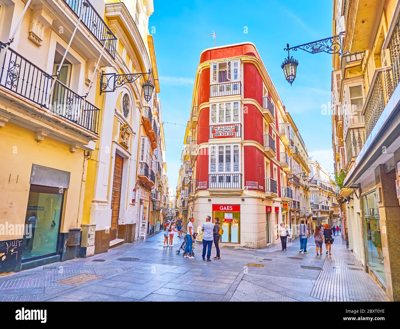 CADIZ, SPAGNA - 23 SETTEMBRE 2019: La facciata ad angolo rosso luminoso dell'edificio storico, che si affaccia sulla famosa Calle Ancha, il 23 settembre a Cadice Foto Stock