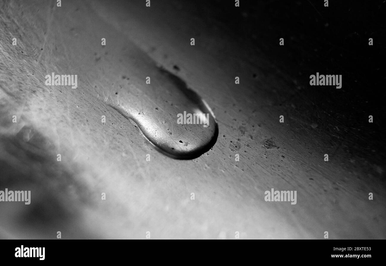 Goccia d'acqua su una superficie metallica vecchia. Balck e bianco Macro foto. Foto Stock