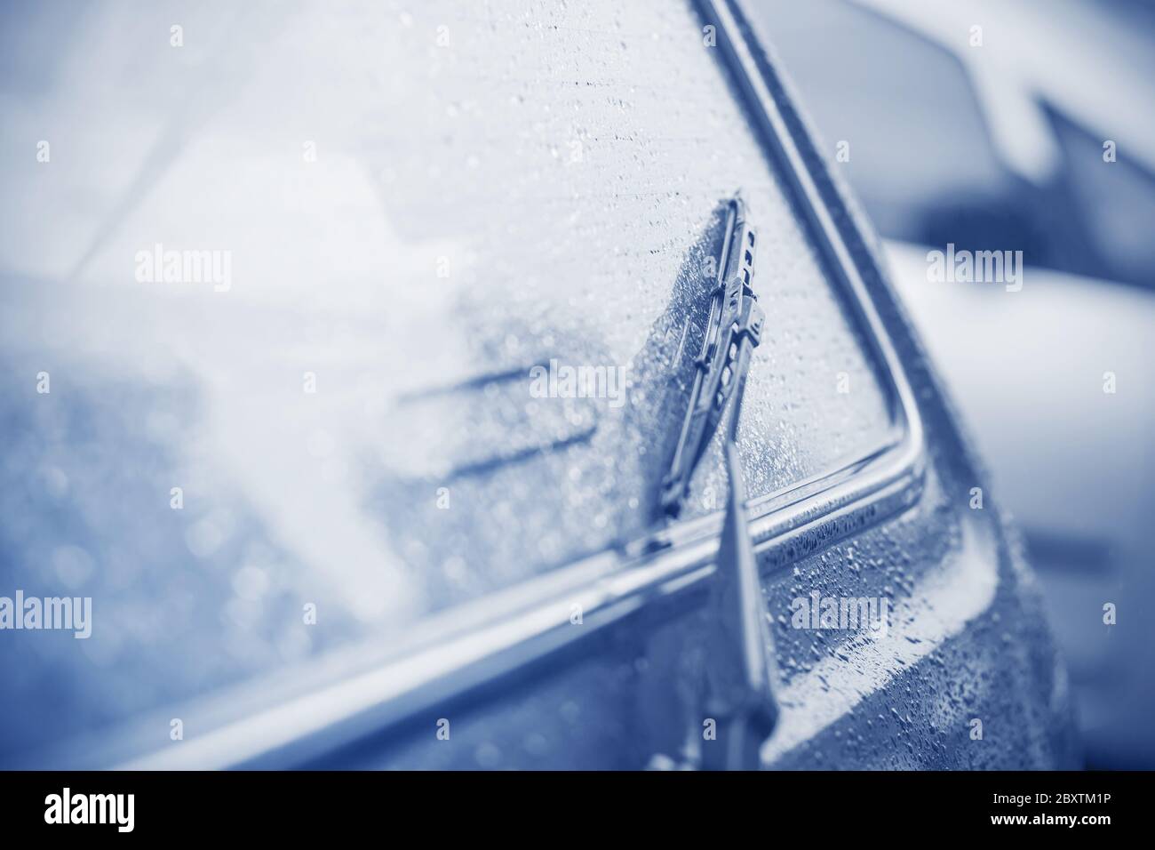 In una giornata nuvolosa e piovosa, il lunotto e il tergicristallo di un'auto sono coperti da gocce di pioggia torrenziale. Tristezza. Malinconia. Maltempo. Foto Stock In una giornata nuvolosa e piovosa, il lunotto e il tergicristallo di un'auto sono coperti da gocce di pioggia torrenziale. Tristezza. Malinconia. Maltempo. Foto Stock