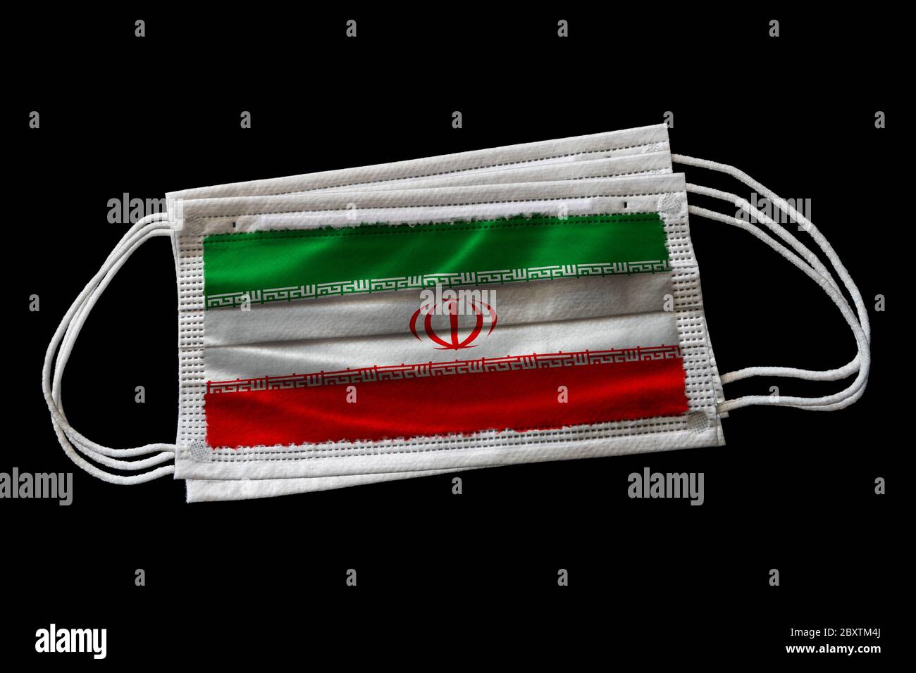 Maschere chirurgiche con bandiera dell'Iran stampata. Isolato su sfondo nero. Concetto di uso della maschera facciale nello sforzo iraniano di combattere il coron Covid-19 Foto Stock