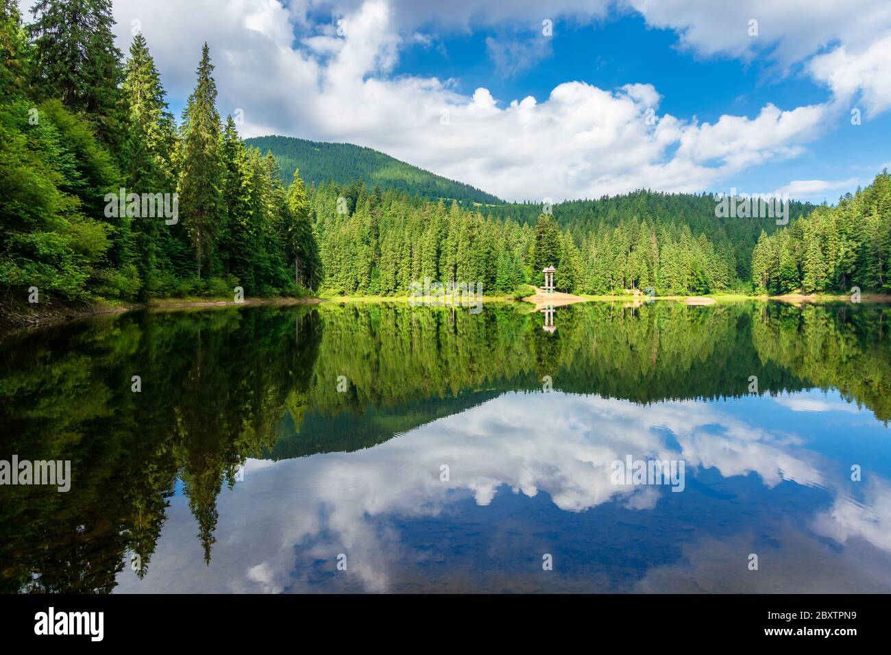 riflessione in acqua. lago tra le foreste. bellissimo paesaggio naturale in estate. tempo soleggiato con nuvole soffici sul cielo Foto Stock