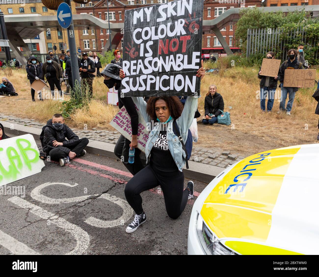 Una donna nera si inginocchiò davanti a una macchina di polizia e tiene un cartello durante la protesta Black Lives Matters a Londra, 6 giugno 2020 Foto Stock Una donna nera si inginocchiò davanti a una macchina di polizia e tiene un cartello durante la protesta Black Lives Matters a Londra, 6 giugno 2020 Foto Stock