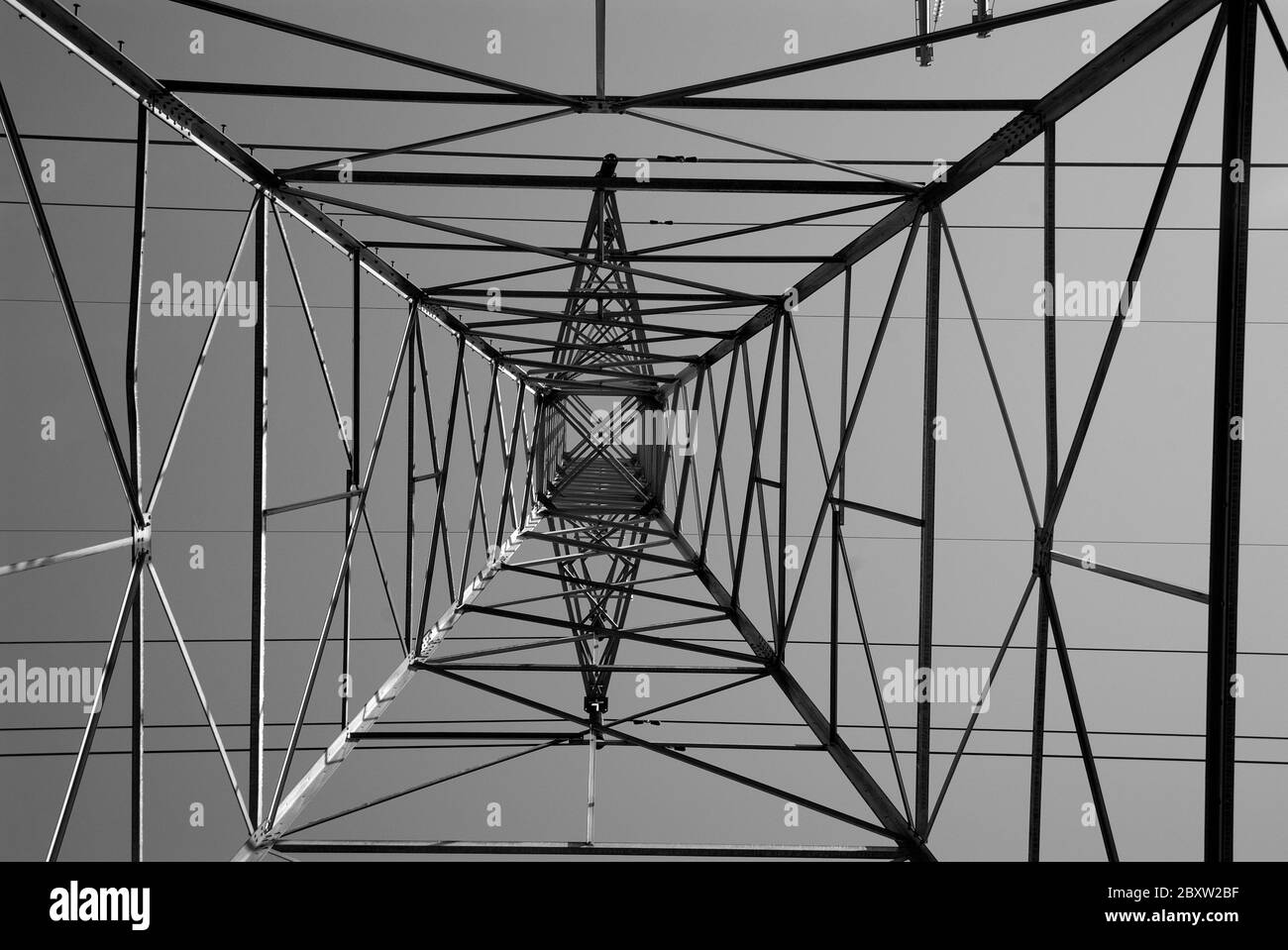 GRIDLOCK: Uno sguardo verticale a 90 gradi alle torri elettriche ad alta tensione dei giorni nostri. Foto Stock