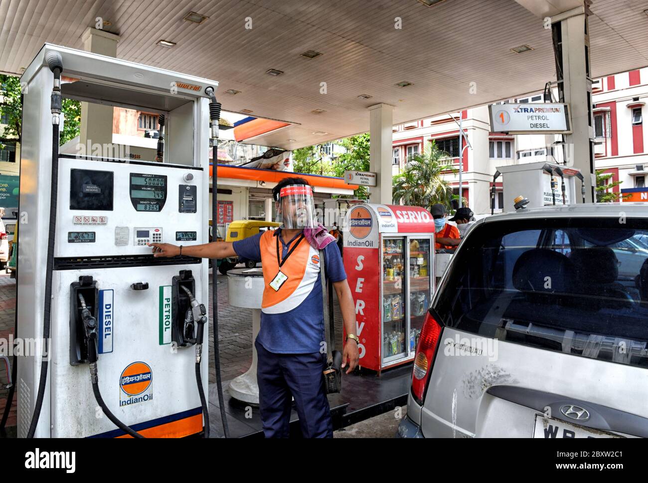 Un dipendente della pompa di benzina dell'olio indiano indossa uno scudo protettivo contro il coronavirus mentre lavora in un punto vendita aperto di Kolkata durante la pandemia di Covid-19.l'India registra 2,64,143 come blocco è stato parzialmente rimosso dal governo indiano dall'8 al giugno 30. Foto Stock