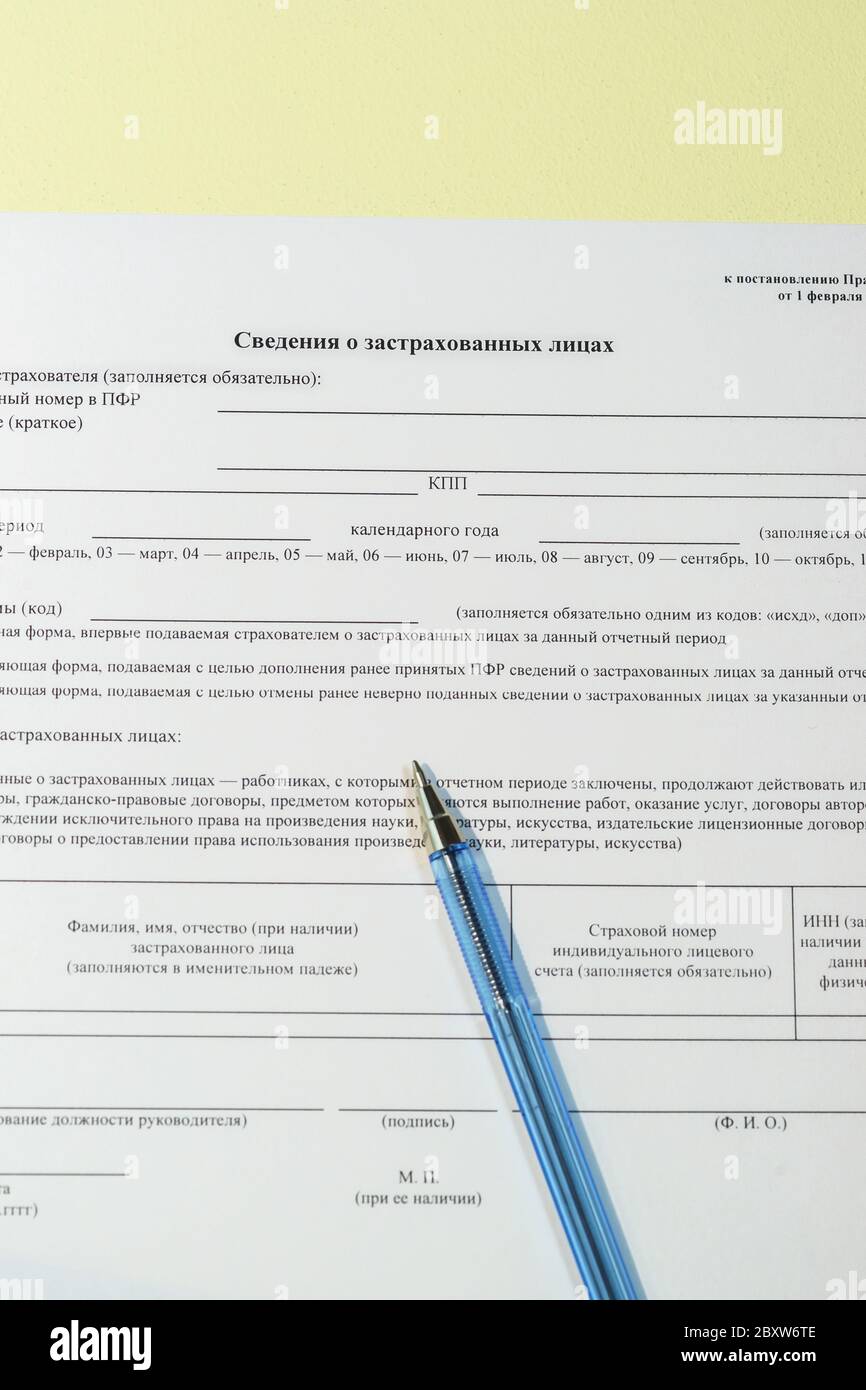 Preparazione di una relazione sui lavoratori dipendenti presso la Cassa pensioni. Testo russo "informazioni sugli assicurati". Un modulo SSV-M vuoto e una penna Foto Stock