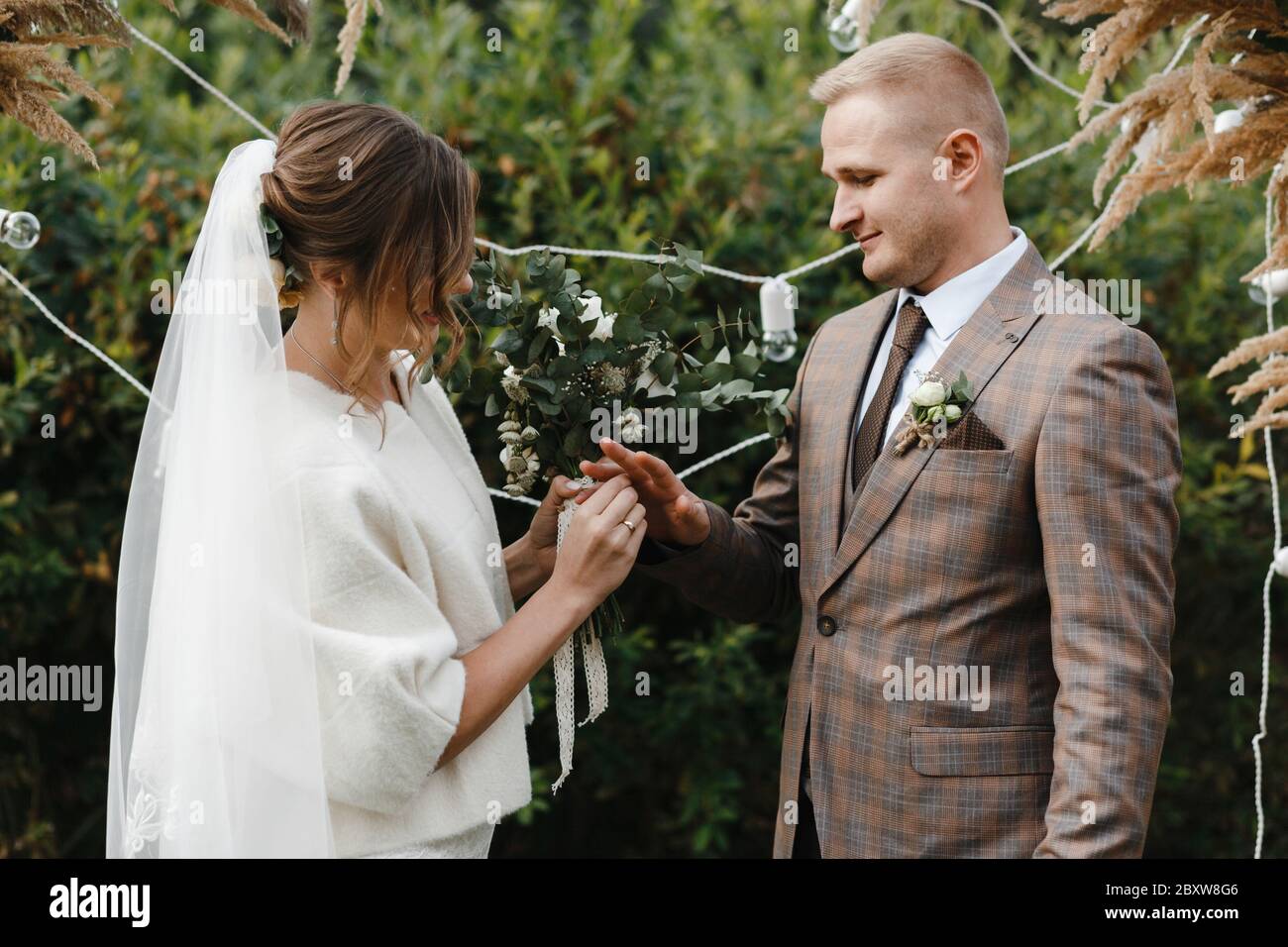 Sposa mettendo l'anello di nozze sul dito dello sposo. Sposa e sposo. Cerimonia nuziale. Foto Stock