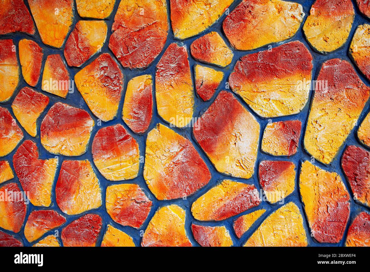 pietre dipinte in rosso e giallo, decorativo sfondo colorato Foto Stock