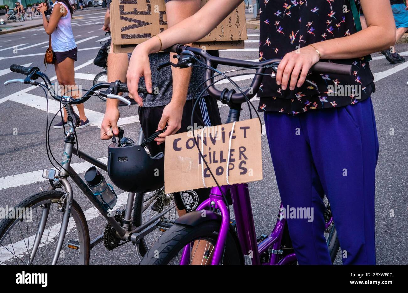 Primo piano di due ciclisti con segni a una marcia di protesta Black Lives Matter a Brooklyn Foto Stock