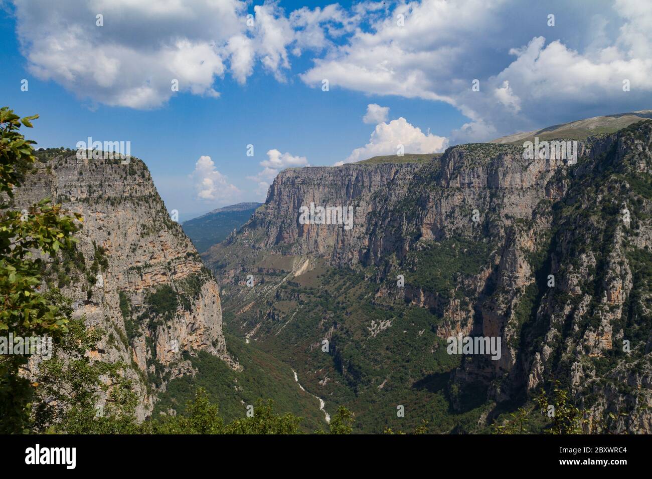 Vikos gola, Epiro, Grecia. Una vista mozzafiato della gola da Oxia, in estate. Il fiume Voidomatis scorre nella gola. Il cielo è parzialmente nuvoloso Foto Stock