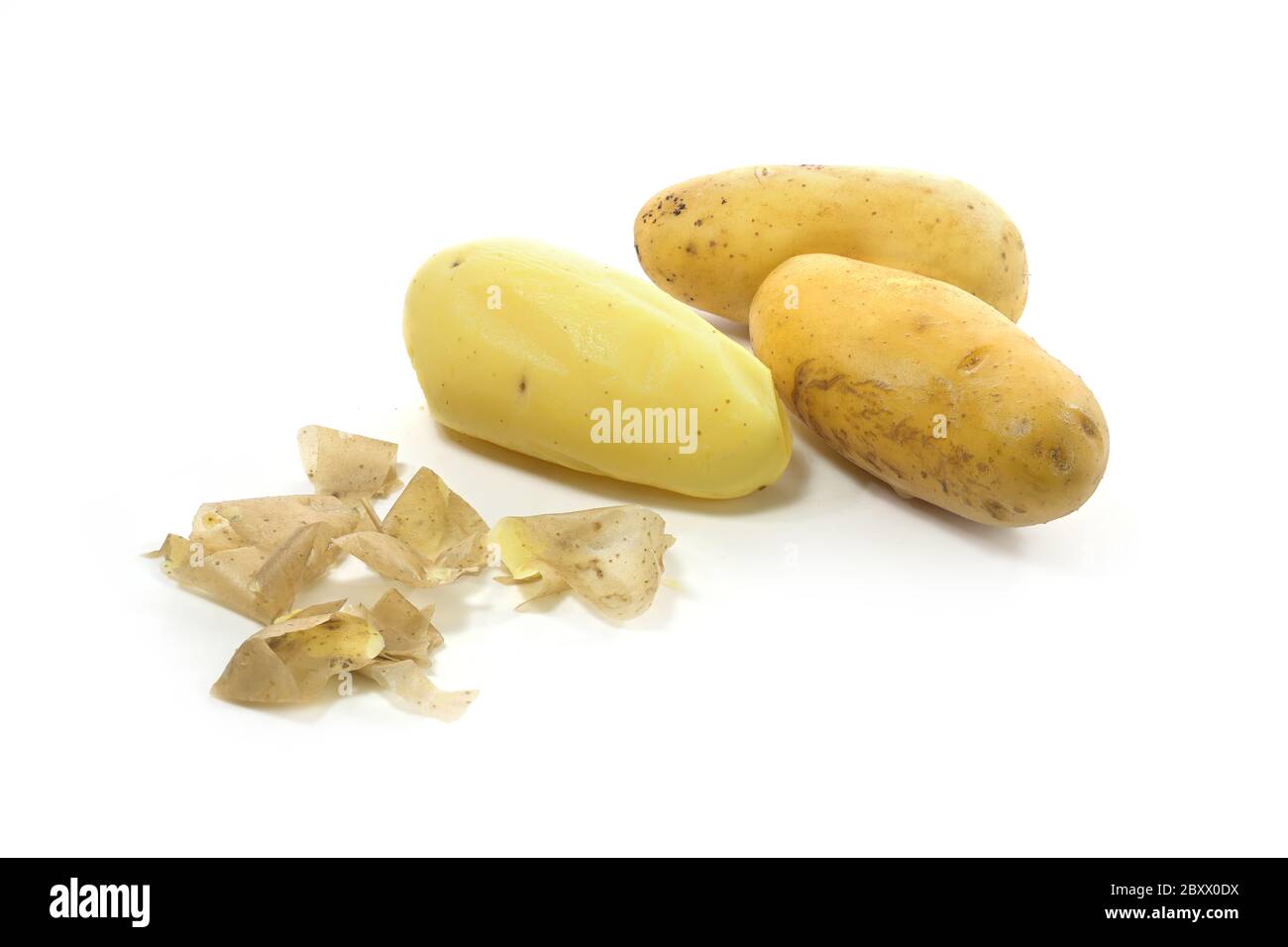 Tre patate giovani bollite nelle loro bucce, una di loro sbucciata, isolata su uno sfondo bianco, spazio di copia Foto Stock