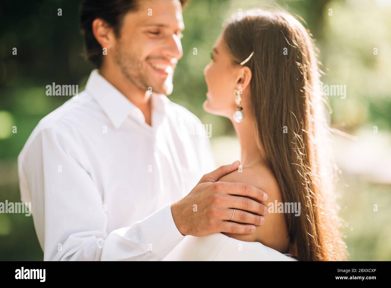 Sposi felici che si guardano l'un l'altro durante la cerimonia di matrimonio all'aperto Foto Stock