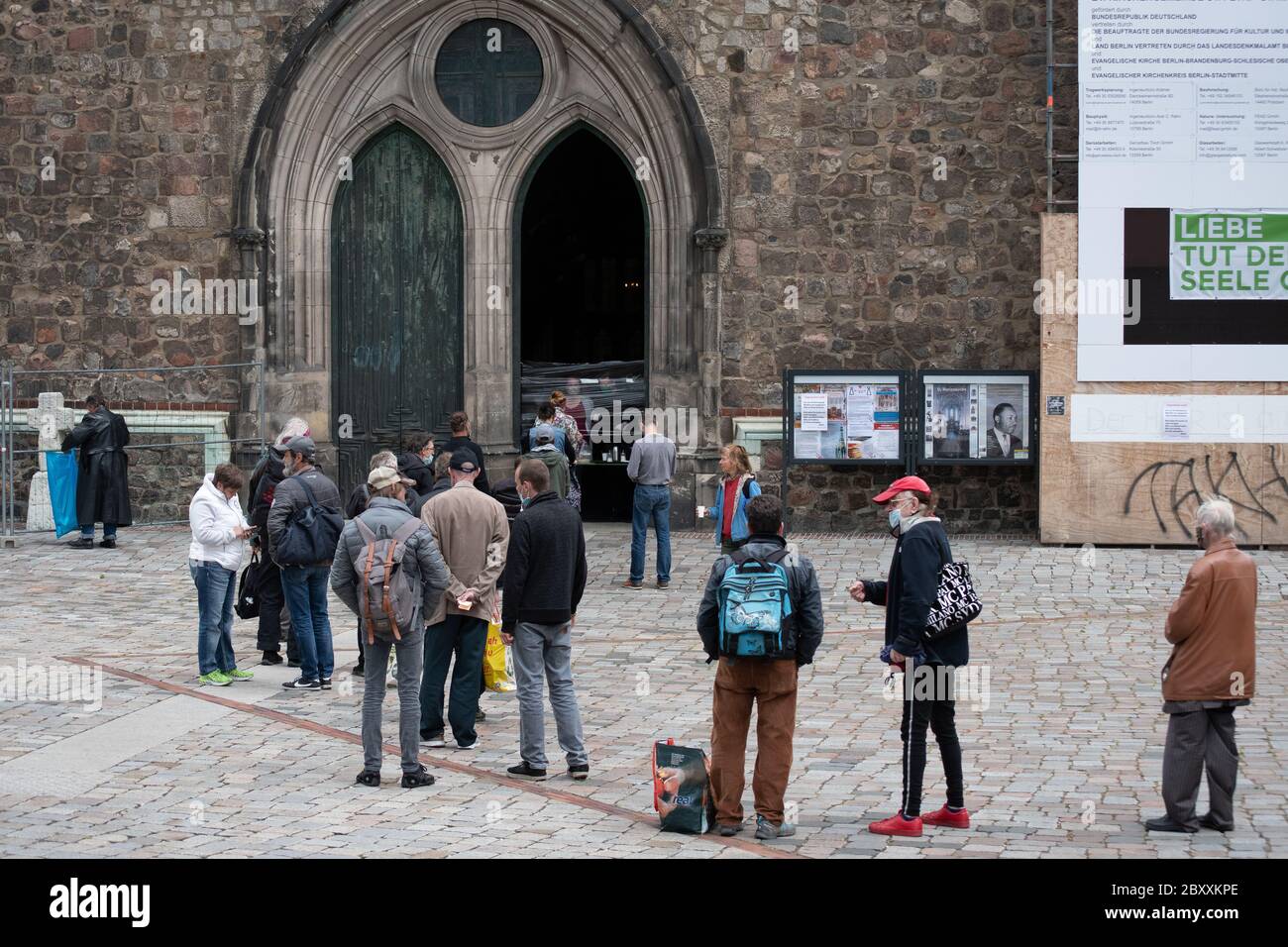 Gruppo di persone in attesa di cibo gratuito in fila davanti a una chiesa di Berlino. Chiesa di Santa Maria, Marienkirche Foto Stock